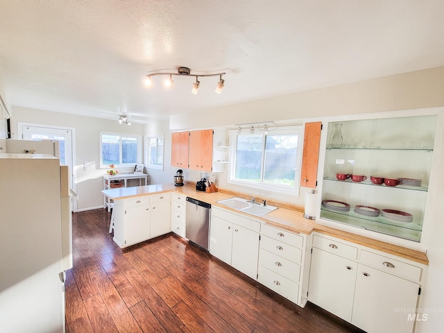 kitchen with white cabinetry, stainless steel dishwasher, kitchen peninsula, and sink