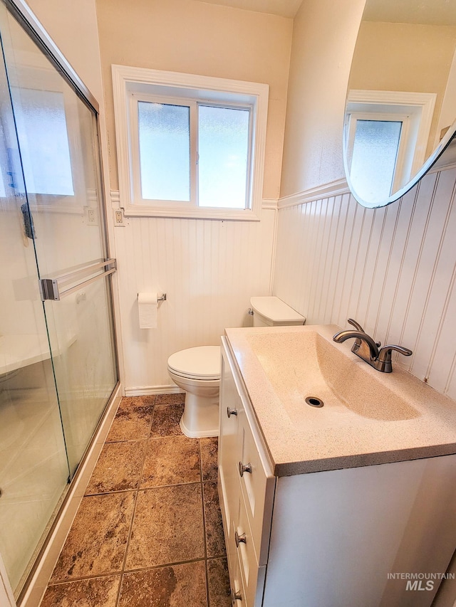 bathroom with vanity, toilet, and a shower with shower door