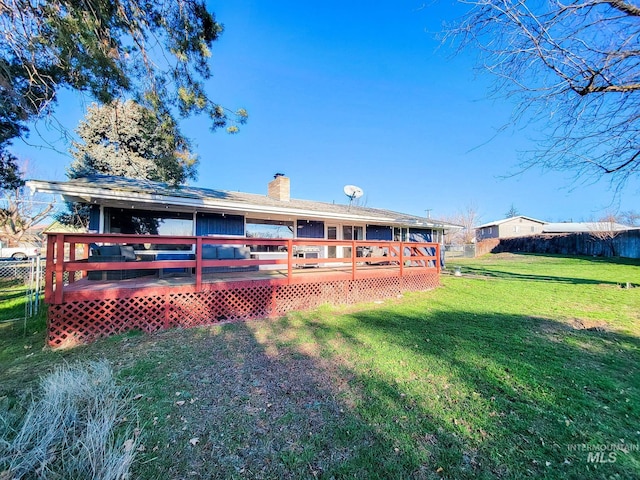 rear view of property with a yard and a deck