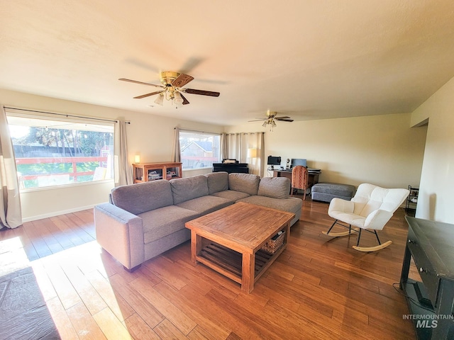 living room featuring wood-type flooring and ceiling fan