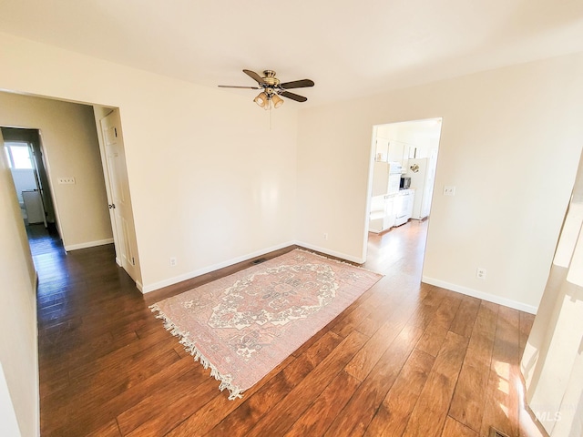 spare room with dark wood-type flooring and ceiling fan