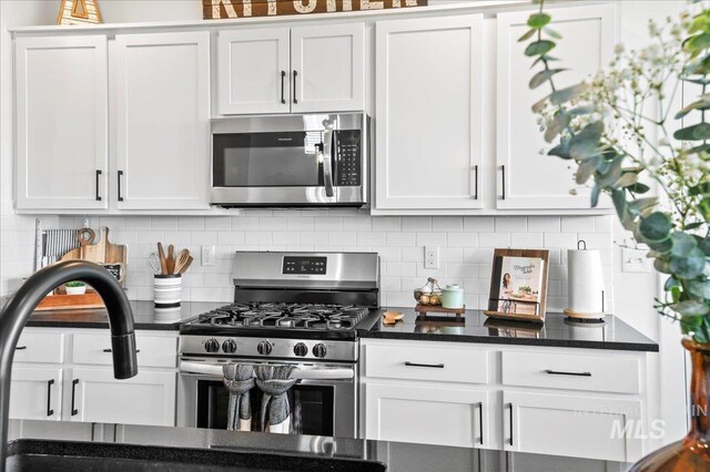 1499 W Blue Downs St, Meridian, ID 83642 - kitchen featuring appliances with stainless steel finishes, white cabinets, backsplash, and dark stone countertops