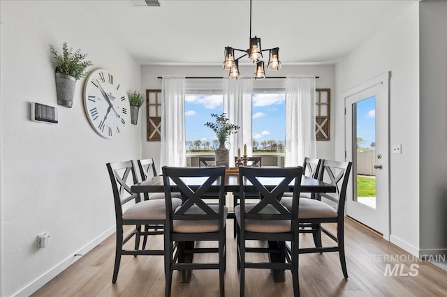 1499 W Blue Downs St, Meridian, ID 83642 - dining room featuring a chandelier, wood finished floors, and baseboards