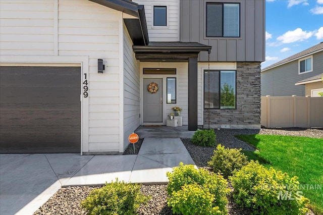 1499 W Blue Downs St, Meridian, ID 83642 - doorway to property with board and batten siding, fence, and stone siding