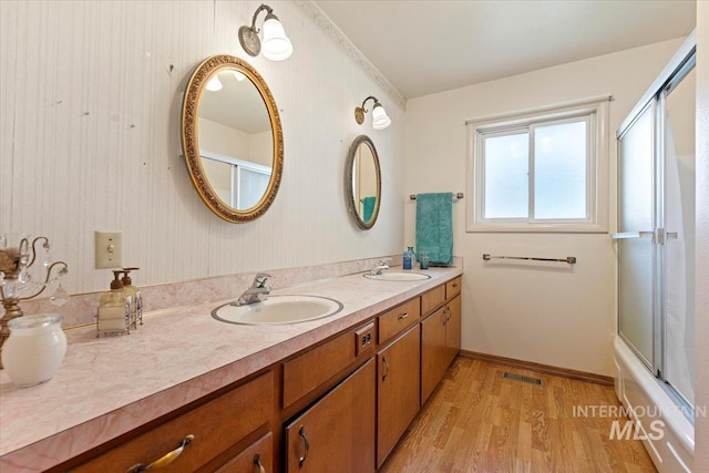 611 E Dewey Ln, Caldwell, ID 83607 - full bath featuring wood finished floors, double vanity, and shower / bath combination with glass door