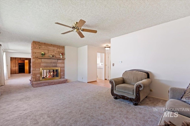 611 E Dewey Ln, Caldwell, ID 83607 - carpeted living area featuring a textured ceiling, ceiling fan, and a stone fireplace