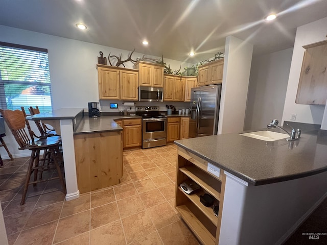 554 Valley Circle Rd, Hagerman, ID 83332 - kitchen with stainless steel appliances, a peninsula, a sink, dark countertops, and a breakfast bar