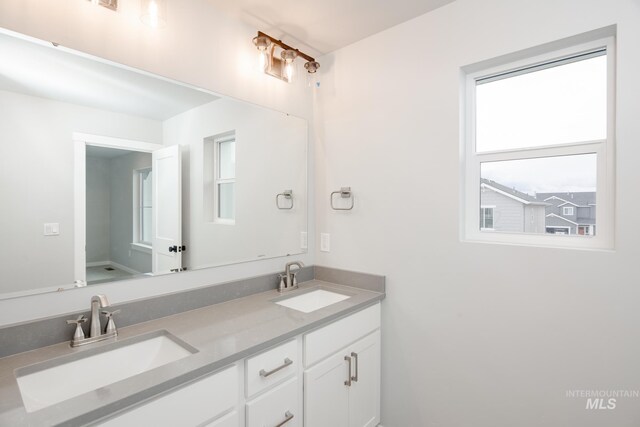 full bathroom with double vanity and a sink