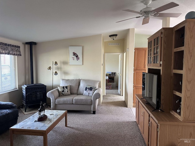17121 Basey St, Murphy, ID 83650 - living area featuring a wood stove, light carpet, ceiling fan, and vaulted ceiling