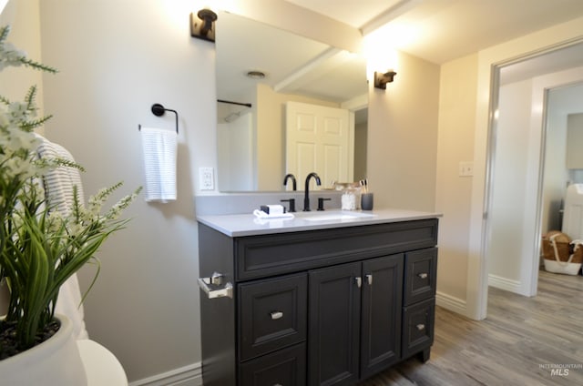 full bath featuring baseboards, a shower, wood finished floors, and vanity