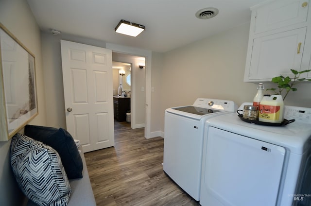 laundry area featuring laundry area, independent washer and dryer, visible vents, wood finished floors, and baseboards