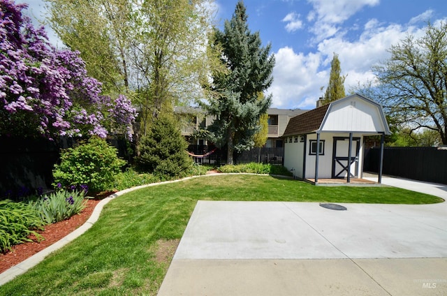 view of yard featuring an outdoor structure, fence, and a shed