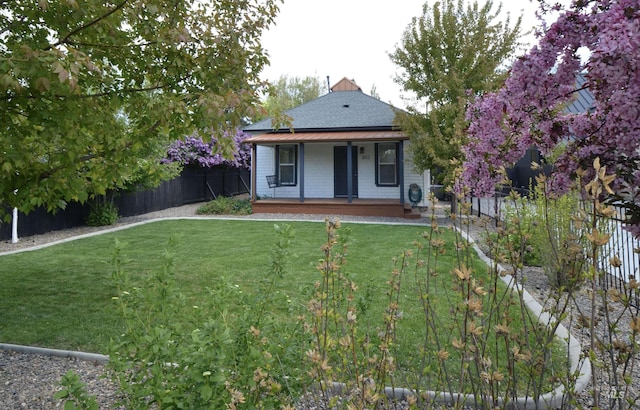 back of property with a porch, a yard, and fence