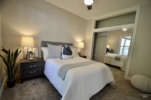 bedroom with dark carpet, baseboards, ceiling fan, and a closet
