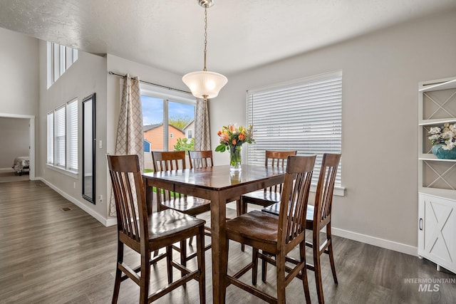 dining room with dark wood-type flooring and baseboards