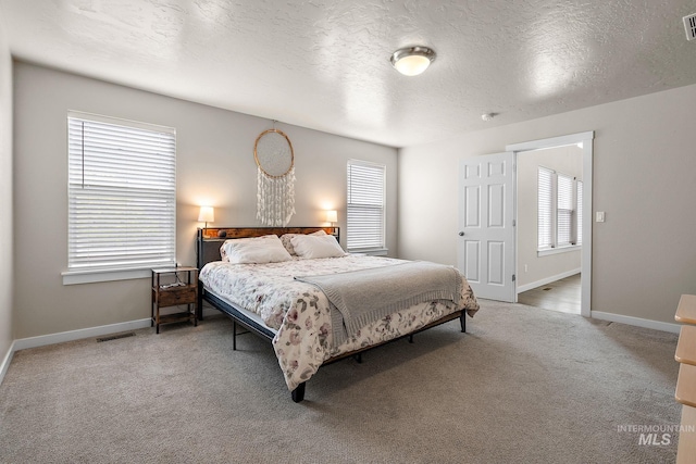 bedroom featuring carpet floors, baseboards, a textured ceiling, and visible vents
