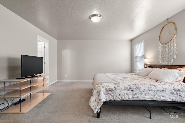 carpeted bedroom with baseboards and a textured ceiling