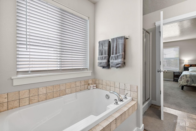 ensuite bathroom featuring ensuite bathroom, a garden tub, and a shower stall