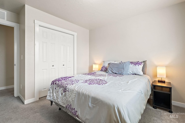 carpeted bedroom with baseboards and a closet