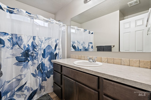 full bath featuring a shower with curtain, visible vents, and vanity