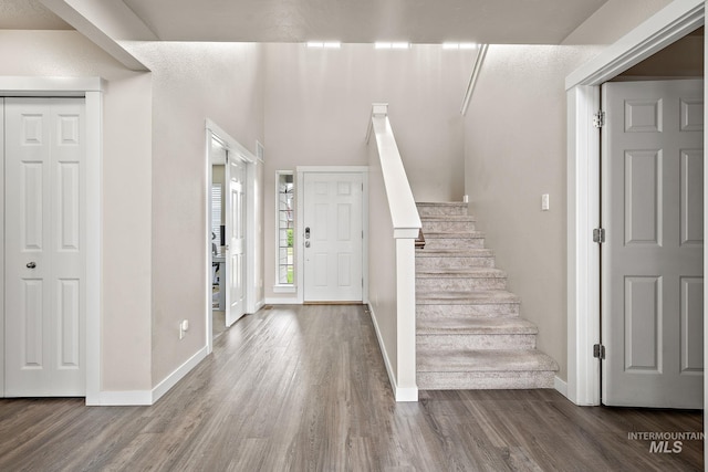 entrance foyer with baseboards, stairs, and wood finished floors