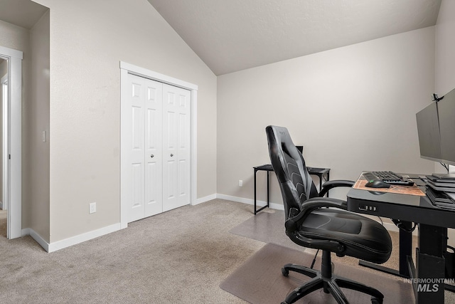 office area featuring carpet floors, baseboards, and lofted ceiling