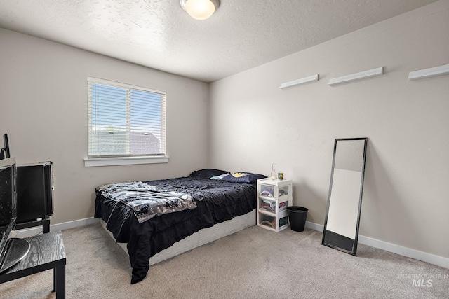 bedroom featuring carpet floors, baseboards, and a textured ceiling