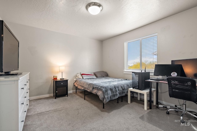 bedroom with a textured ceiling, light carpet, and baseboards