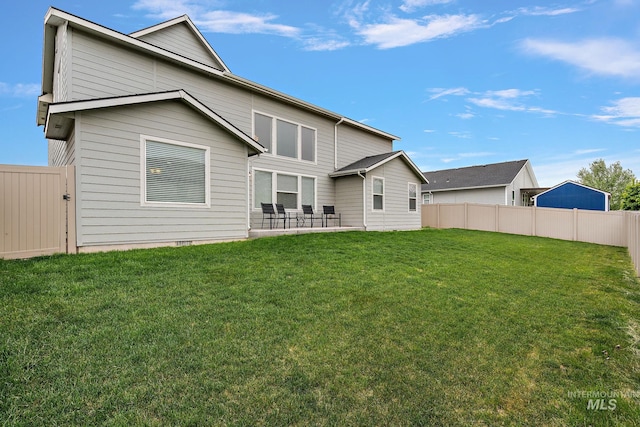 back of house featuring a lawn, fence, and a patio