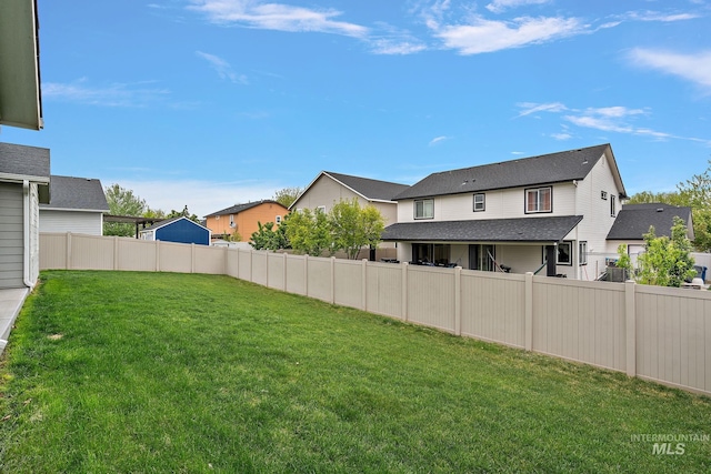 view of yard featuring a fenced backyard and a residential view