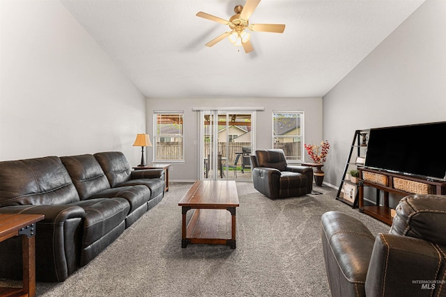living area featuring baseboards, ceiling fan, carpet flooring, and lofted ceiling