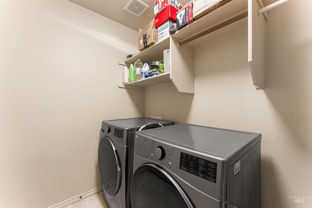 washroom featuring laundry area, baseboards, washing machine and dryer, and visible vents