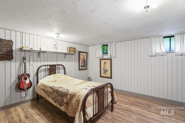 bedroom featuring a textured ceiling and wood finished floors