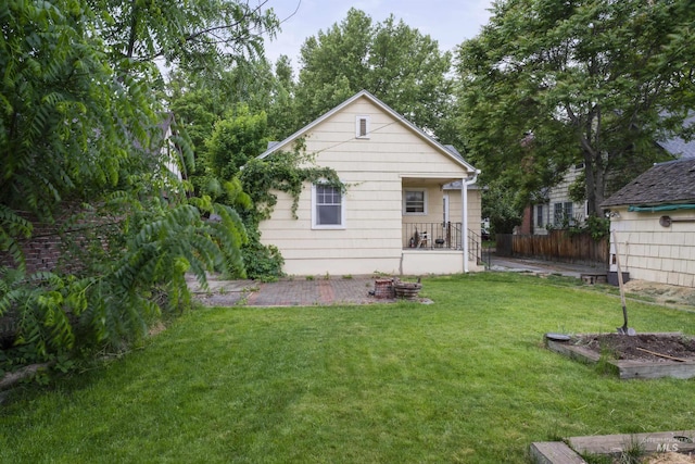 back of property featuring fence and a lawn