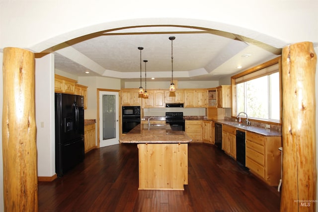 19801 Pinehaven Ln, Lenore, ID 83541 - kitchen featuring black appliances, a tray ceiling, light brown cabinets, arched walkways, and a center island with sink