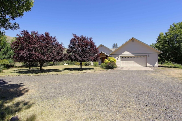 19801 Pinehaven Ln, Lenore, ID 83541 - obstructed view of property featuring an attached garage and gravel driveway