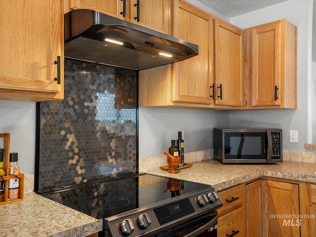 12800 W Fernleaf St, Boise, ID 83713 - kitchen with under cabinet range hood, electric range, stainless steel microwave, and decorative backsplash