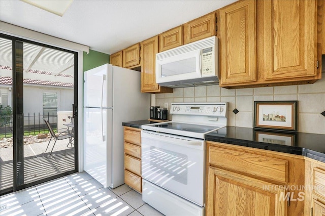 255 Los Lagos, Twin Falls, ID 83301 - kitchen with white appliances, light tile patterned floors, dark countertops, and tasteful backsplash