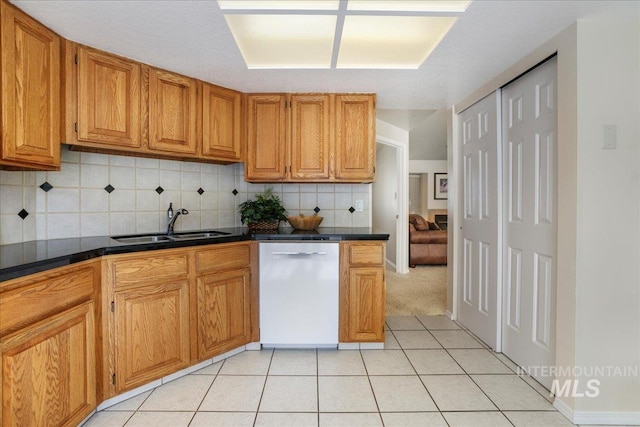 255 Los Lagos, Twin Falls, ID 83301 - kitchen with white dishwasher, a sink, light tile patterned floors, decorative backsplash, and dark countertops
