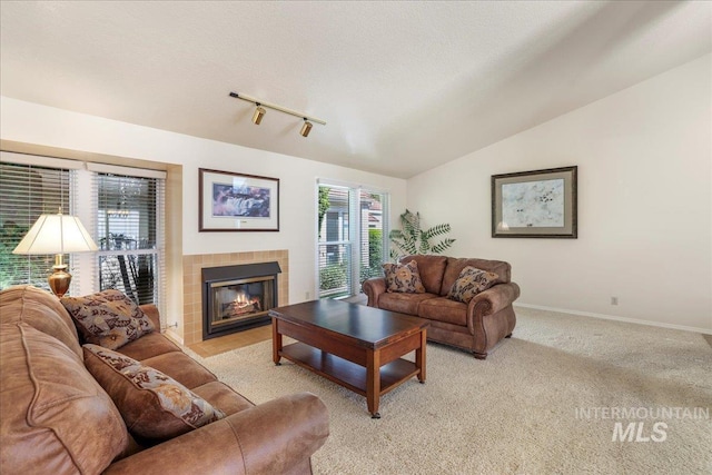 255 Los Lagos, Twin Falls, ID 83301 - living room with a tiled fireplace, light colored carpet, baseboards, lofted ceiling, and rail lighting