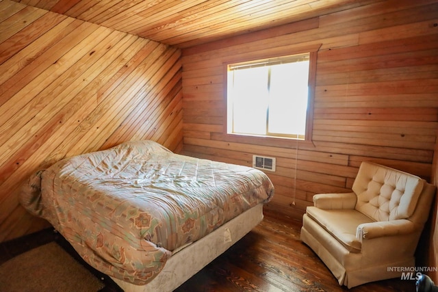 bedroom with wood walls, visible vents, wood ceiling, and wood finished floors