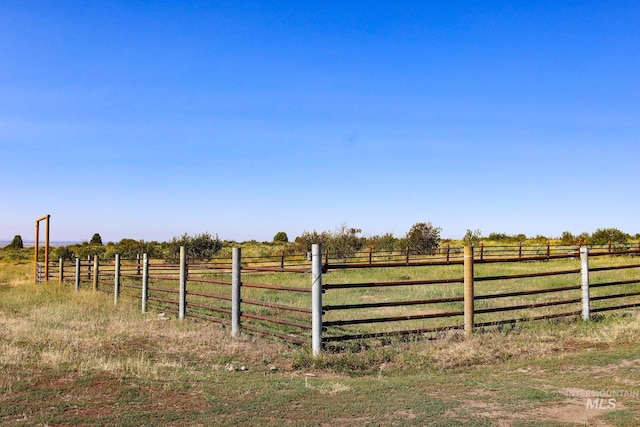 view of yard with fence and a rural view
