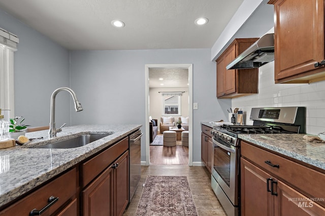 3209 W Plant Dr, Boise, ID 83703 - kitchen featuring appliances with stainless steel finishes, wall chimney exhaust hood, a sink, light stone countertops, and backsplash