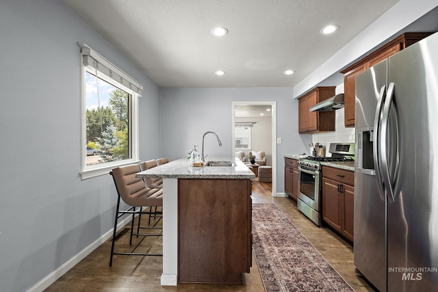 3209 W Plant Dr, Boise, ID 83703 - kitchen with stainless steel appliances, a sink, recessed lighting, wall chimney exhaust hood, and light stone counters