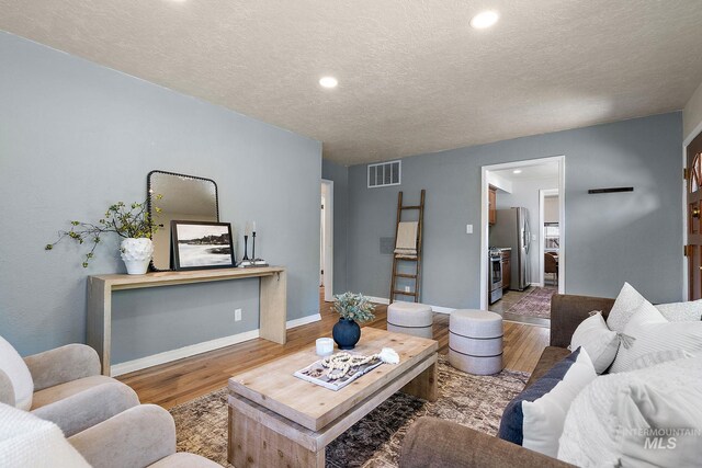 3209 W Plant Dr, Boise, ID 83703 - living room featuring wood finished floors, a textured ceiling, recessed lighting, and baseboards