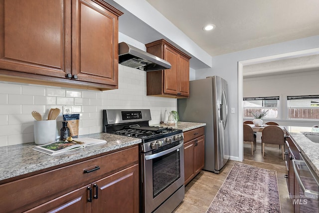 3209 W Plant Dr, Boise, ID 83703 - kitchen featuring appliances with stainless steel finishes, wall chimney range hood, backsplash, and light stone countertops