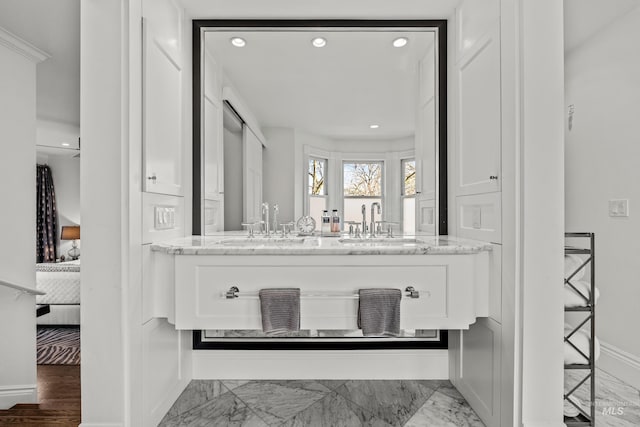 full bath with vanity, baseboards, recessed lighting, marble finish floor, and connected bathroom