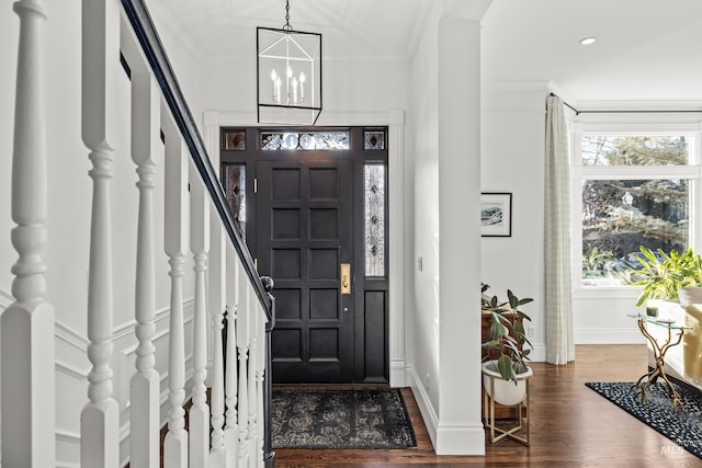 entrance foyer featuring dark wood finished floors, stairway, and crown molding