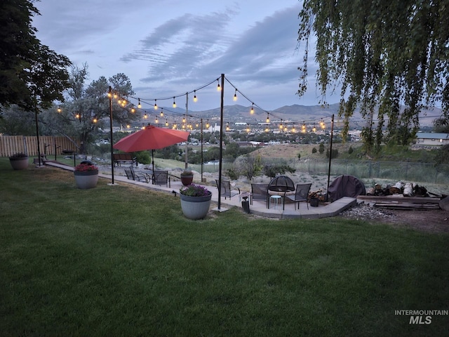 view of home's community featuring an outdoor fire pit, a yard, and a mountain view