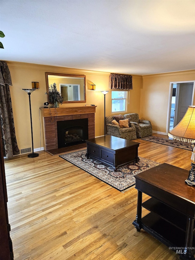 living room featuring light hardwood / wood-style flooring and ornamental molding